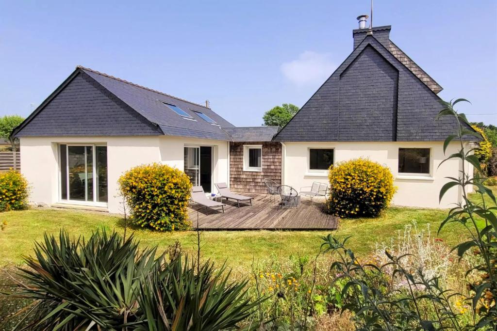 ein weißes Haus mit einer Terrasse im Hof in der Unterkunft Beautiful villa with heated indoor pool, large garden close to beach, 8 people in Moëlan-sur-Mer