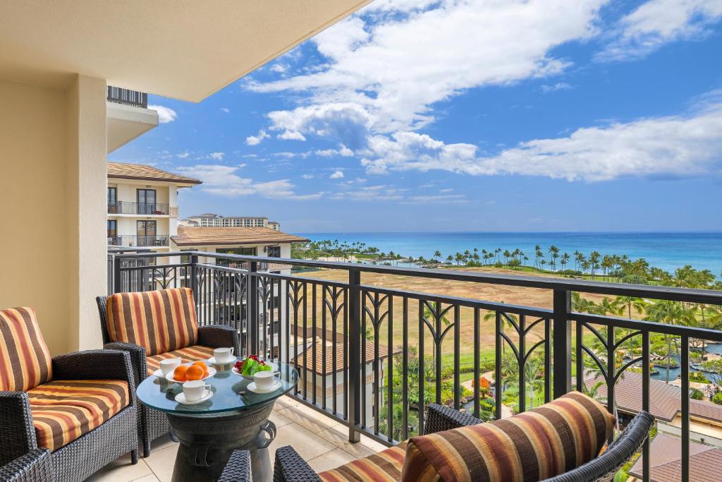 d'un balcon avec des chaises et une table offrant une vue sur l'océan. dans l'établissement Ko Olina Beach Villas O1001, à Kapolei