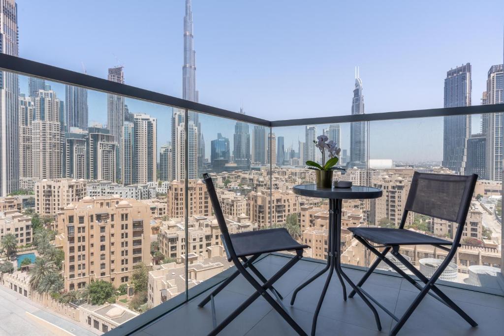 2 sillas y una mesa en un balcón con vistas al perfil urbano en Lux BnB Bellevue Tower Burj Khalifa Views, en Dubái