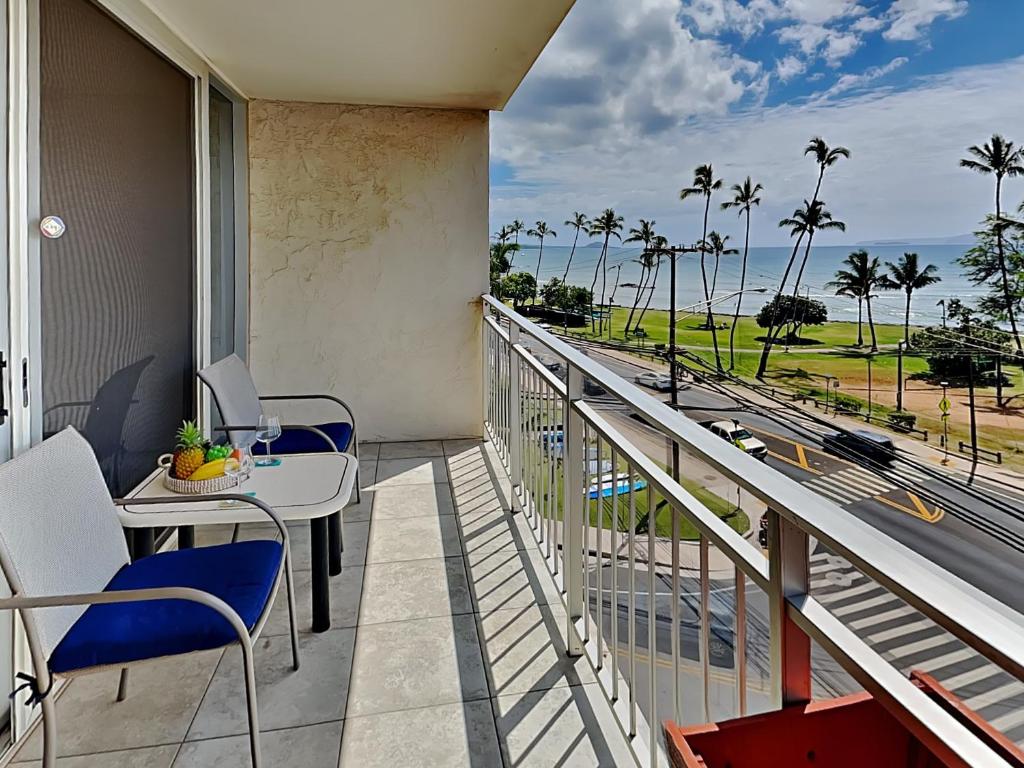 a balcony with a table and chairs and a view of the ocean at Island Surf 506 in Kihei