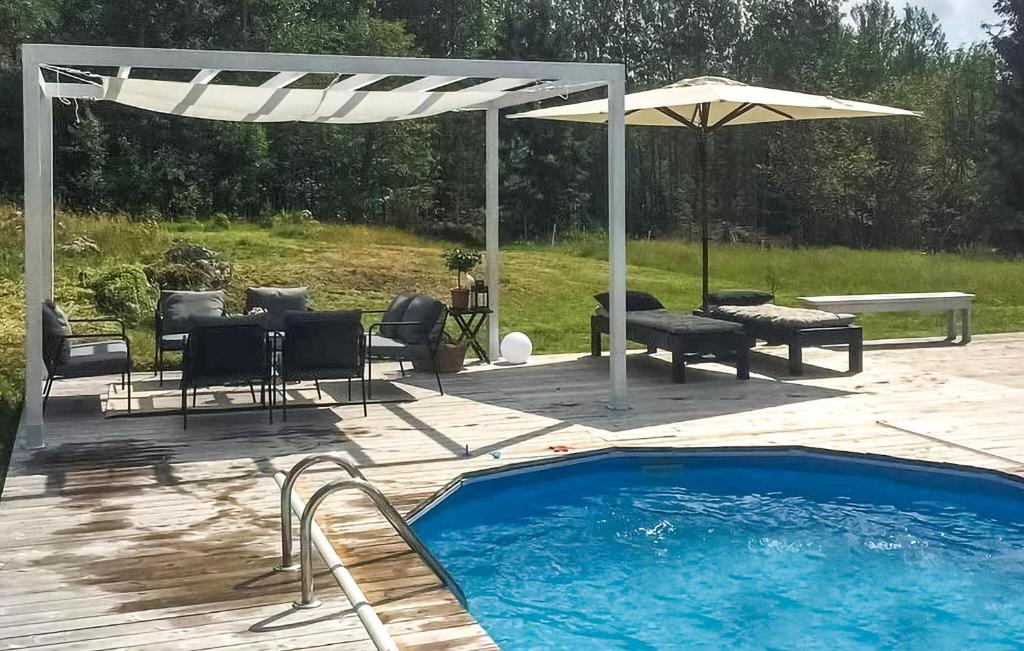 patio con piscina e ombrellone di Cozy Home In Nrkesberg With Outdoor Swimming Pool a Närkesberg
