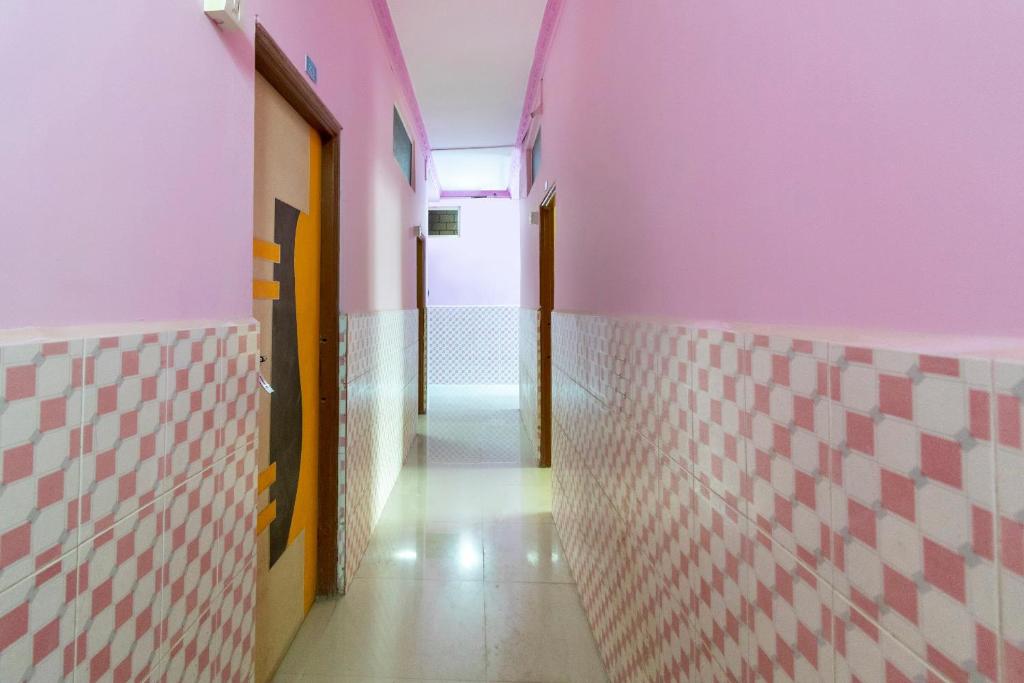 a hallway with pink walls and white tiles at SPOT ON Shree Gajanan in Aurangabad
