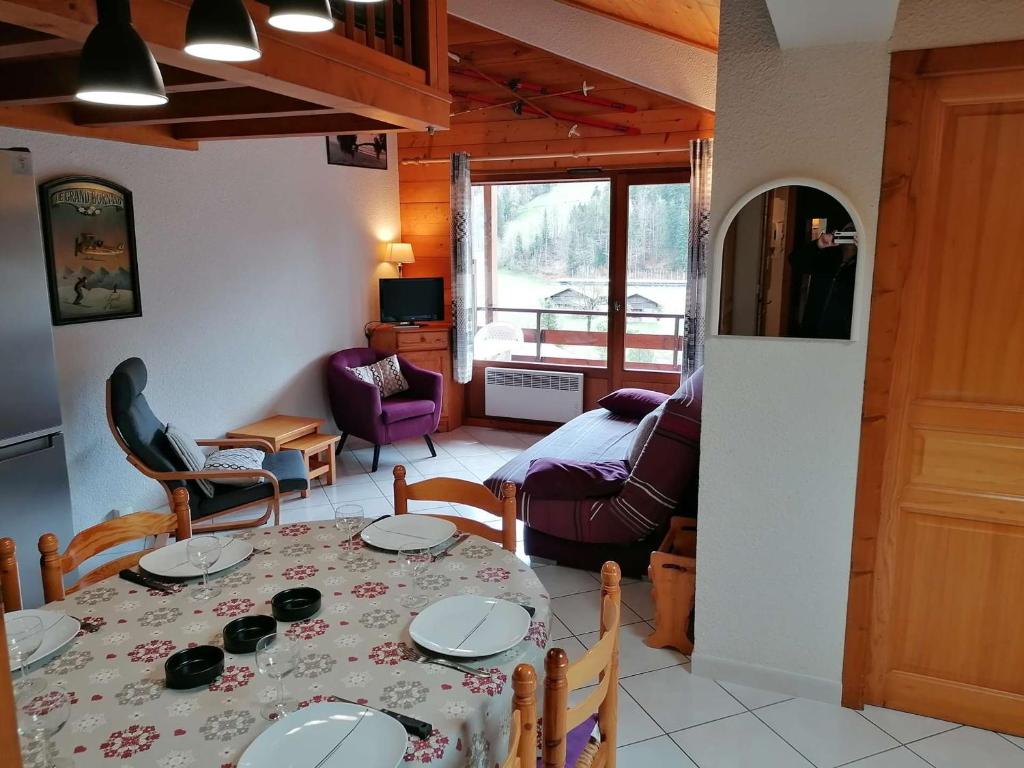 a dining room with a table and a living room at Appartement Le Grand-Bornand, 3 pièces, 6 personnes - FR-1-241-61 in Le Grand-Bornand
