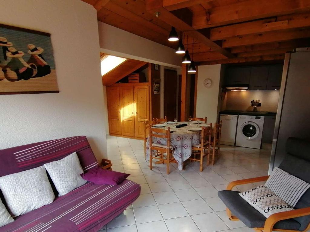 a living room with a purple couch and a kitchen at Appartement Le Grand-Bornand, 3 pièces, 6 personnes - FR-1-241-61 in Le Grand-Bornand