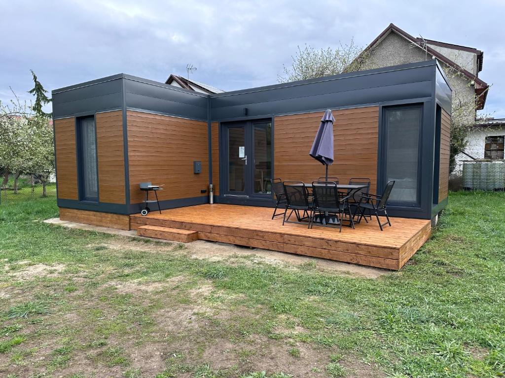 a house with a deck with a table and an umbrella at Domek letniskowy Ińsko BIO BOX in Ińsko