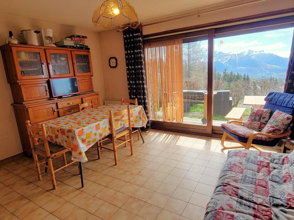 d'une salle à manger avec une table et une vue sur la montagne. dans l'établissement Appartement cosy 5 pers, terrasse sud, parking, proche station, animaux acceptés - FR-1-393-127, à Saint-Michel-de-Chaillol