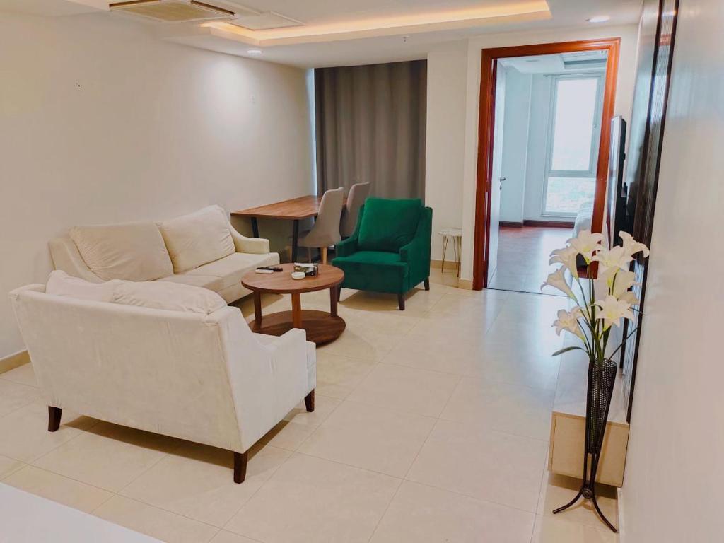 uma sala de estar com um sofá, uma mesa e cadeiras em One bed appartment in GOLDCrest DHA Lahore em Lahore