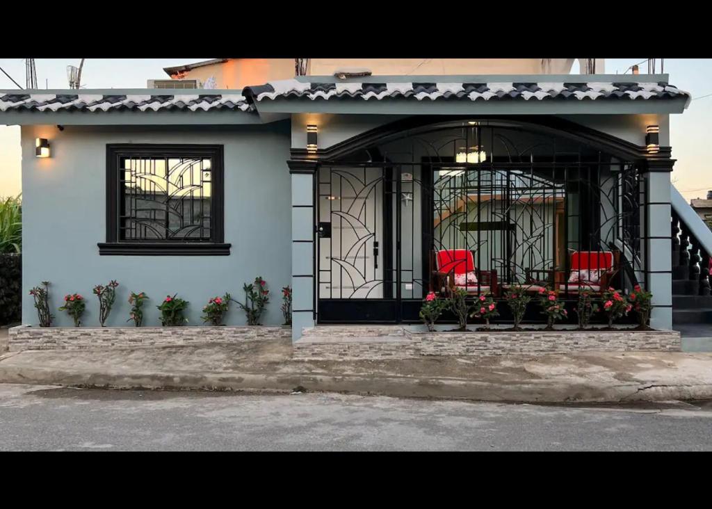 a house with two red chairs on the front porch at E & J Lifestyle in Río San Juan