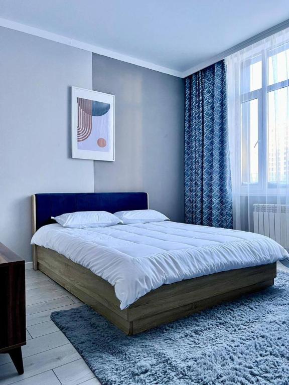 Un dormitorio con una cama grande y una ventana en Expo New Life 4, en Prigorodnyy