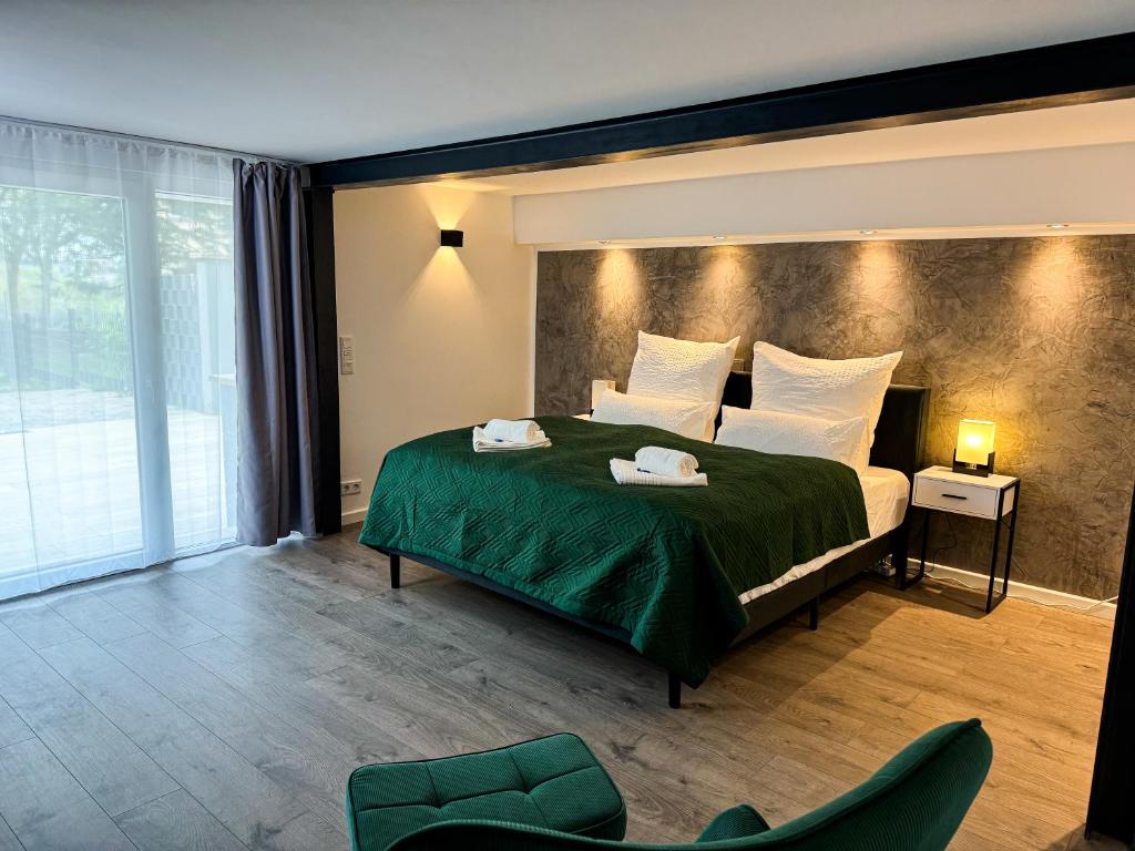 een slaapkamer met een groot bed en een groene deken bij ROTH Apartments Velbert-Mitte in Velbert