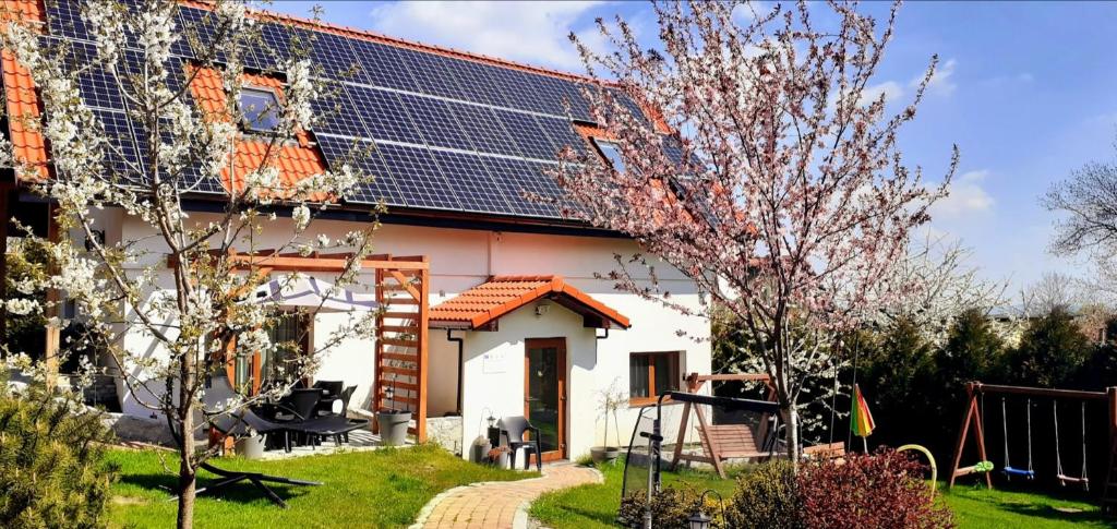 a house with solar panels on the roof at Dom Pod Różami Agroturystyka in Srebrna Góra