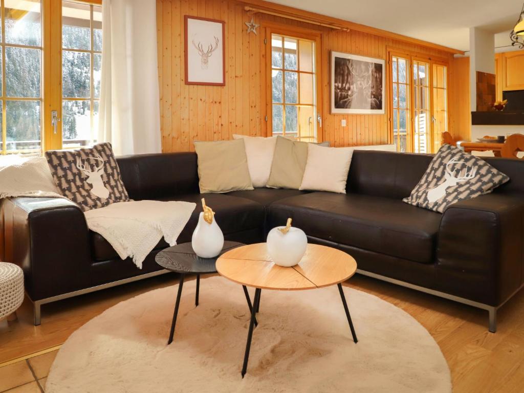 sala de estar con sofá de cuero negro y mesa en Apartment Colline 8 by Interhome, en Champex