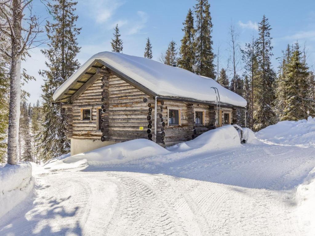eine Blockhütte im Schnee mit einem Schneehaufen in der Unterkunft Holiday Home Muuttohaukka by Interhome in Ruka