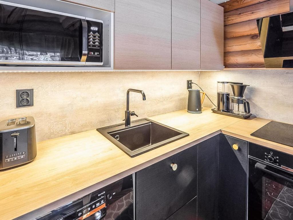 a kitchen with a sink and a microwave at Holiday Home Tiira by Interhome in Himahuuha