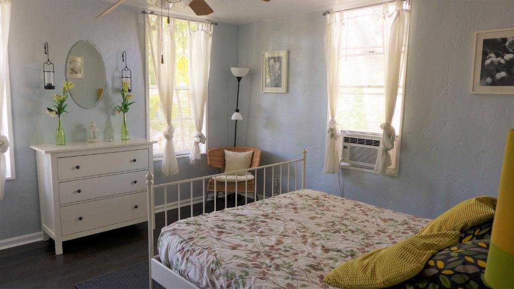 um quarto com uma cama, uma cómoda e janelas em Barra Villa Resort House I em Fort Myers