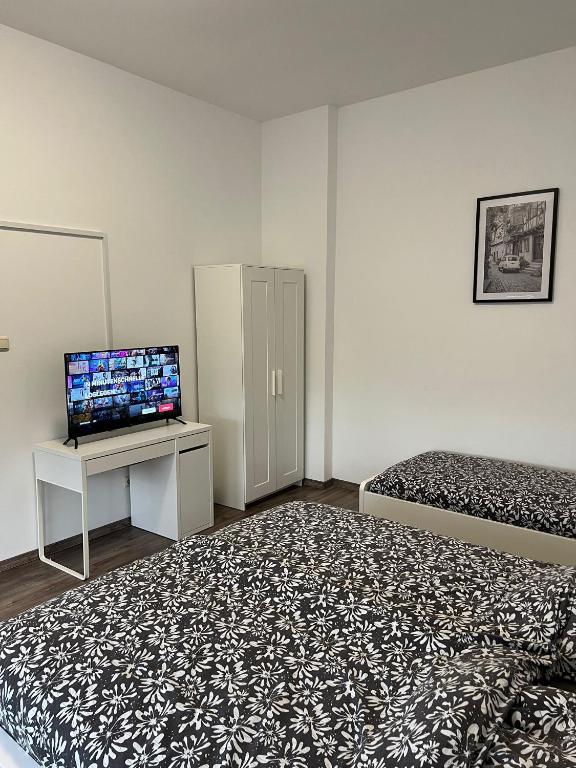 Habitación pequeña con 2 camas y TV. en Apartments im Herzen von Velbert, en Velbert