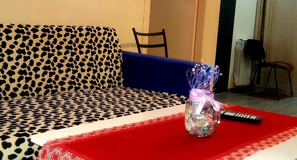 a vase sitting on a couch with a remote control at tamunas apartment in Tbilisi City