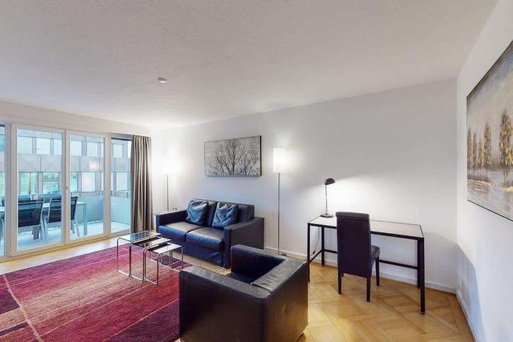 a living room with a couch and a table at Bright 1 bedroom flat in the city centre (Greenyard 2) in Zürich