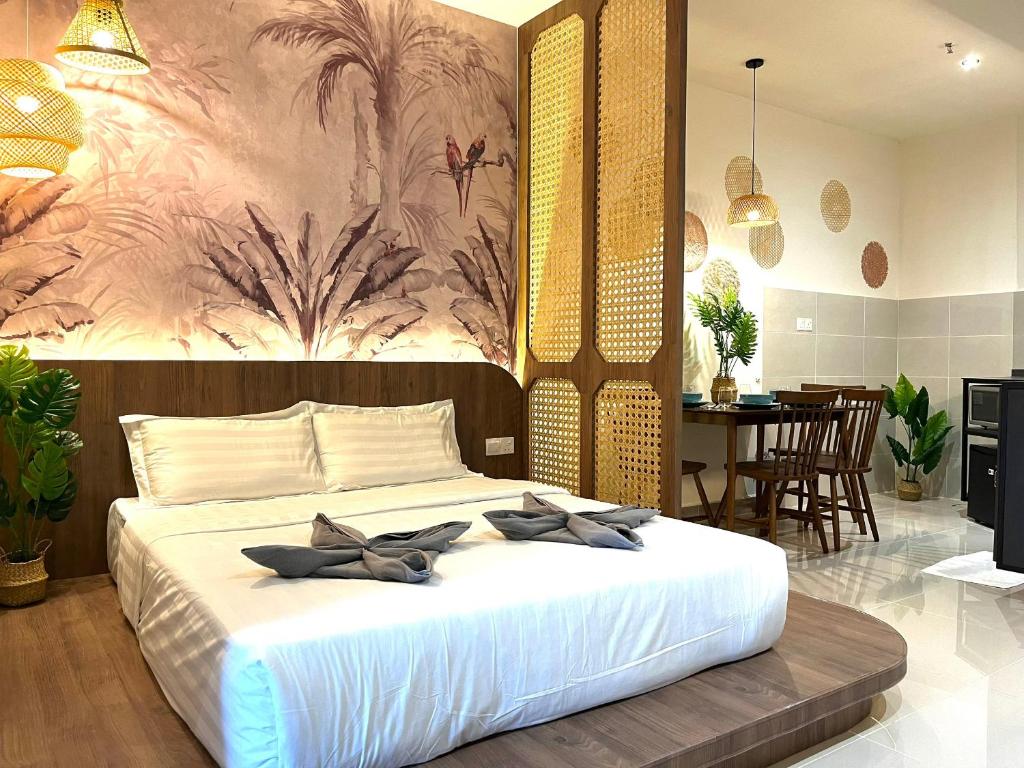 una camera da letto con un grande letto bianco e un dipinto sul muro di Covesign Suite a Kota Kinabalu