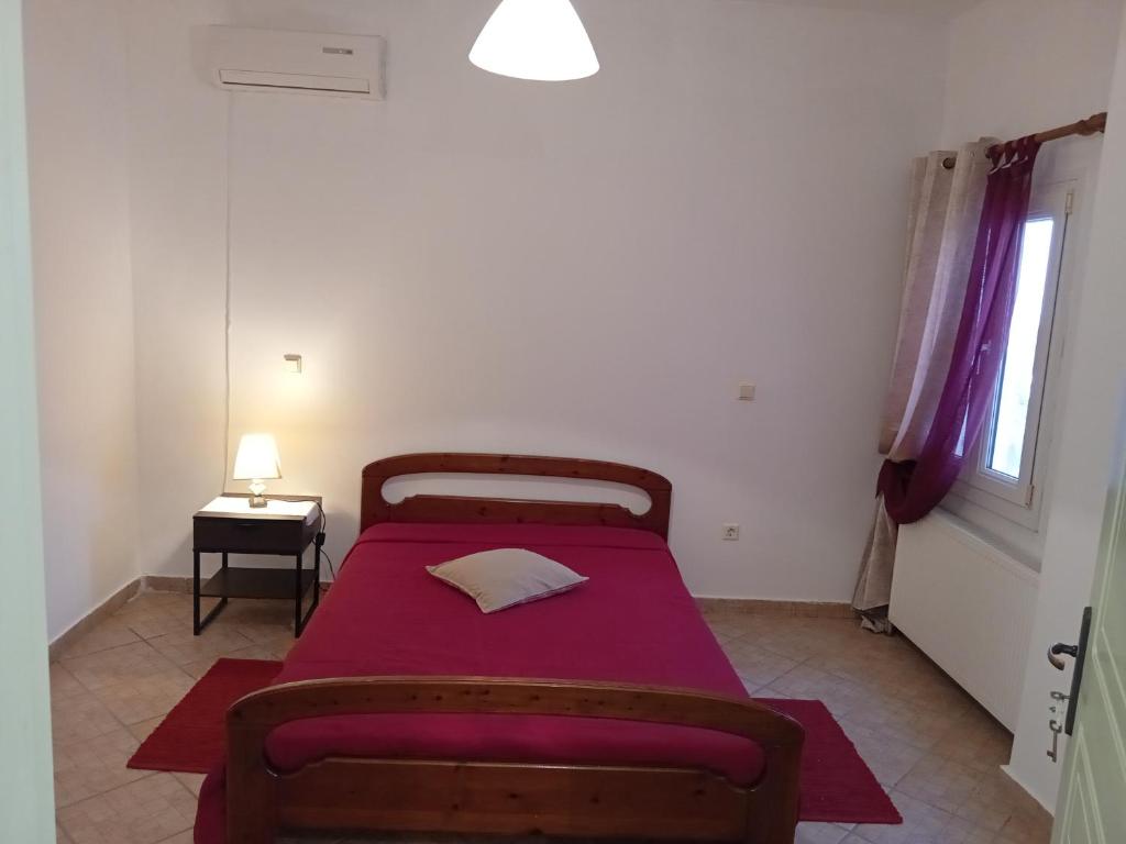 - une chambre avec un lit doté de draps violets et une fenêtre dans l'établissement ΘΈΑ, à Rogón
