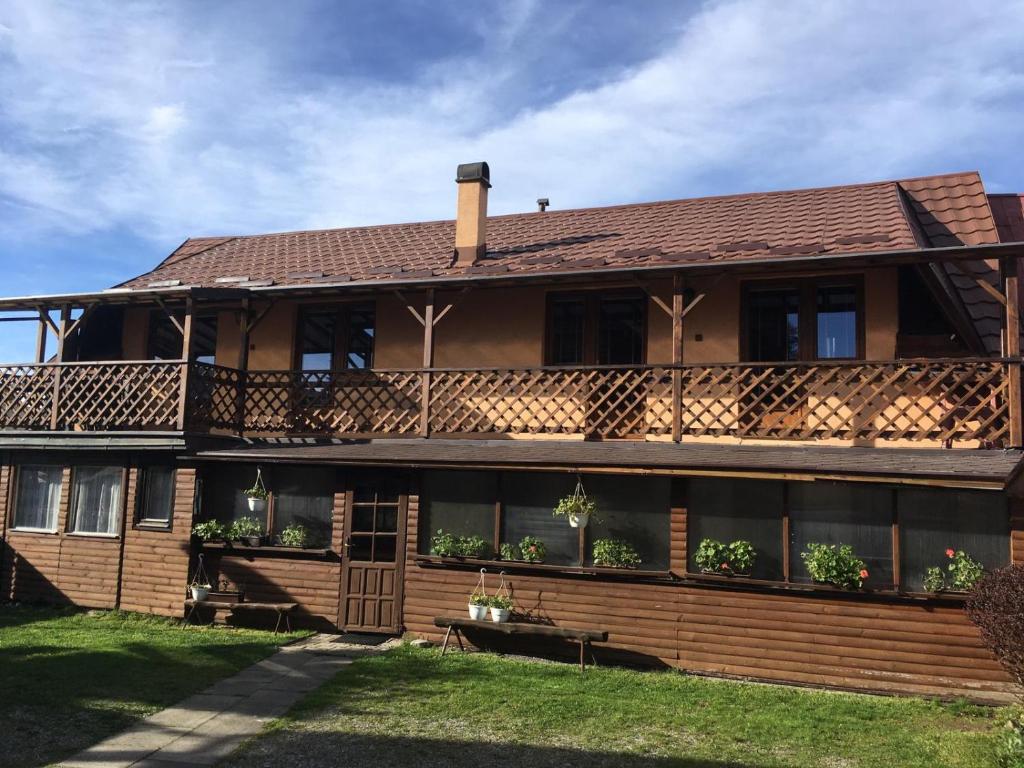 ein großes Holzhaus mit einer Veranda in der Unterkunft Penzión Janka in Zuberec