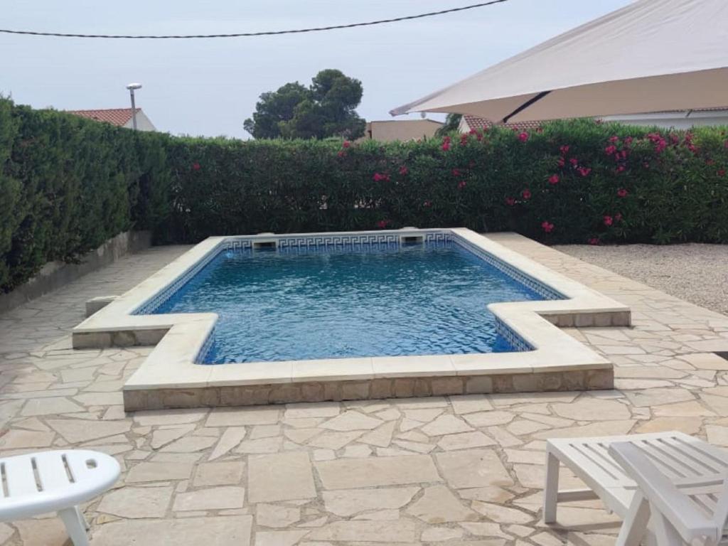 uma piscina num pátio com uma mesa e cadeiras em Villa Villa Olivos by Interhome em L'Ametlla de Mar