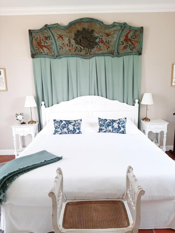 a bedroom with a large white bed with a canopy at Maison Coqueréaumont in Montagne
