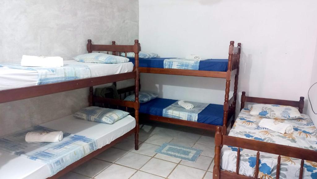 a room with three bunk beds in a room at Villa dos Pássaros Paraty Hospedagem in Paraty