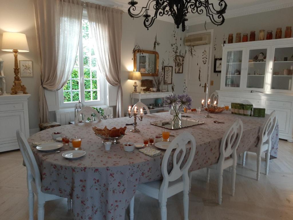 a dining room with a table and chairs with candles at Maison Coqueréaumont in Montagne