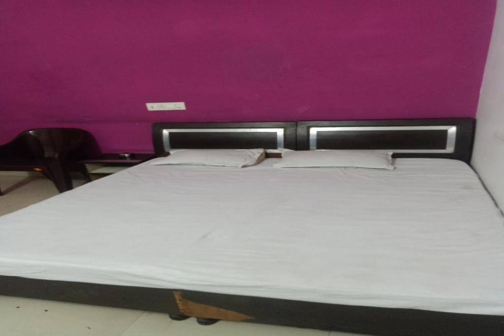 Posteľ alebo postele v izbe v ubytovaní OYO Mahima Hotel