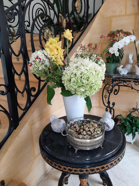 a table with a vase and flowers on a staircase at Maison Coqueréaumont in Montagne