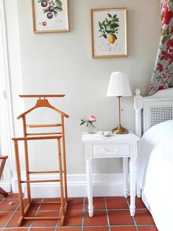 a bedroom with a table and a chair next to a bed at Maison Coqueréaumont in Montagne