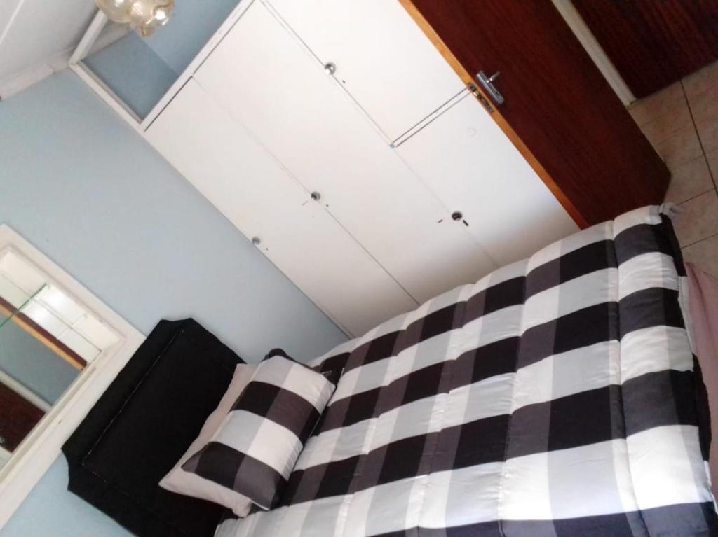 a bed with black and white checkered sheets in a room at M&T Guesthouse in Orkney