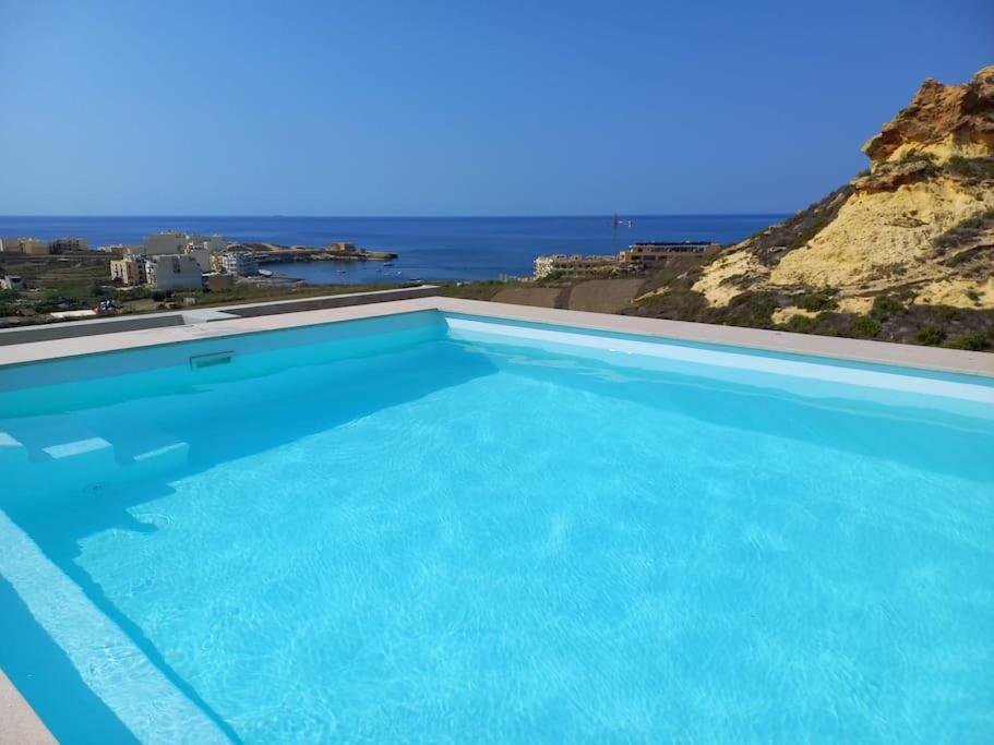 una grande piscina con vista sull'oceano di Yellow Hill Penthouse a Żebbuġ
