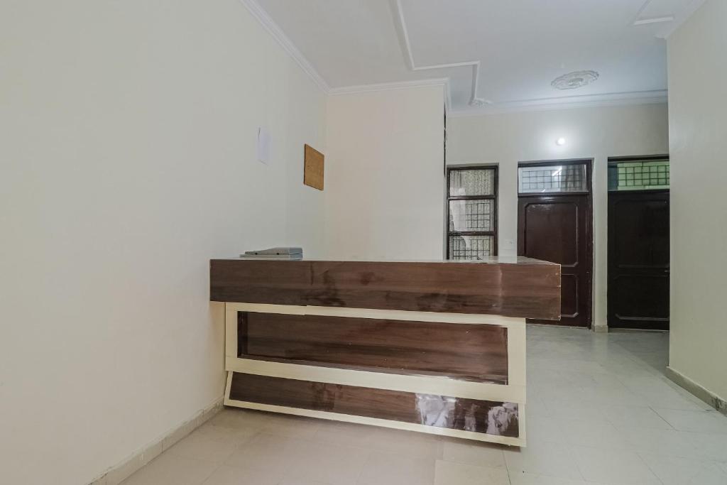 OYO Hc Plaza في Kharar: طاولة خشبية في غرفة مع جدار