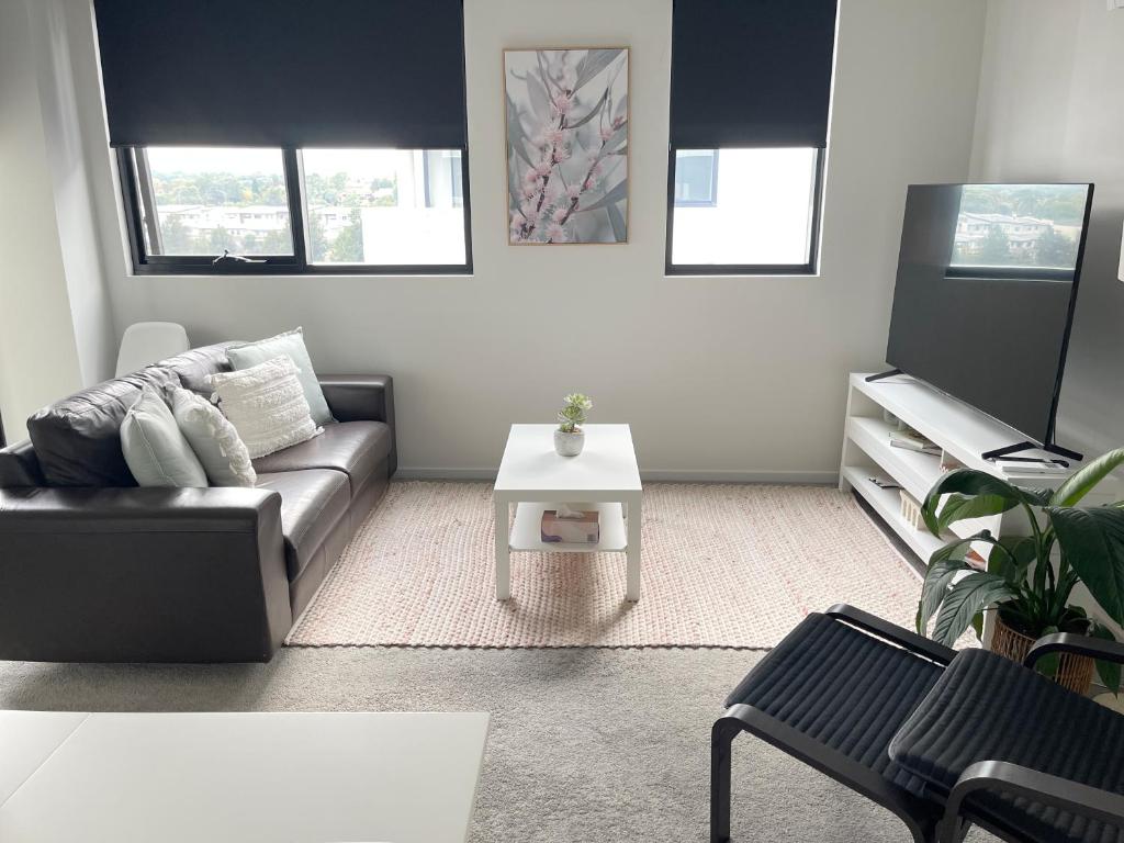 a living room with a couch and a table at Blackdiamond 504 - Beautiful, modern apartment - 2BdR, 2BthR in Tuggeranong