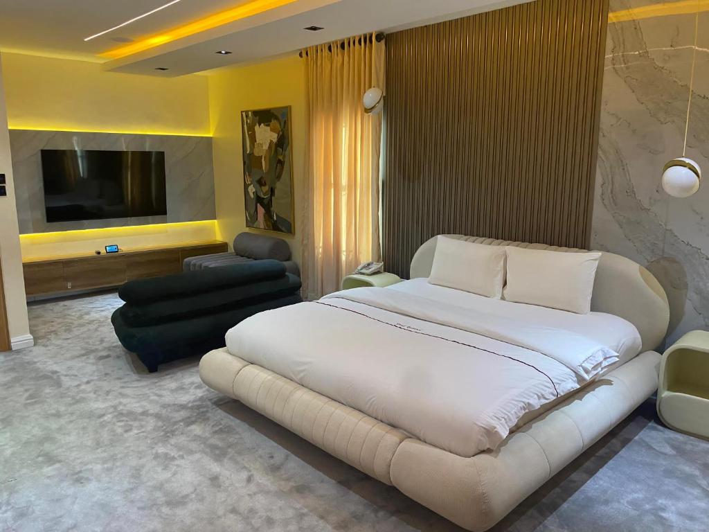 a bedroom with a large bed and a living room at PROOF RESIDENCE in Lekki