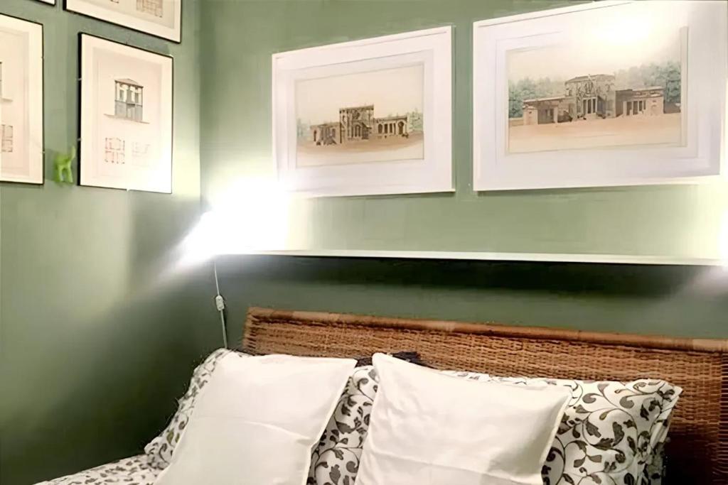 ein Schlafzimmer mit grünen Wänden und einem Bett mit weißen Kissen in der Unterkunft Studio with wifi at Firenze in Florenz