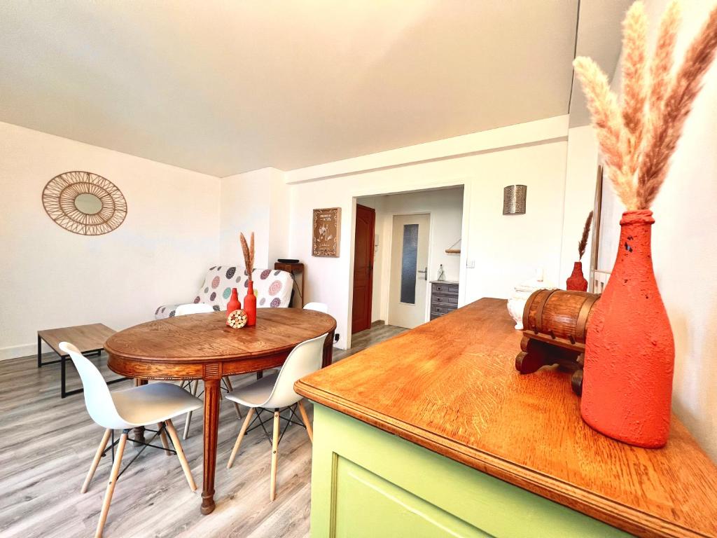 a kitchen and dining room with a table and vases at Appartement proche gare, 6 voyageurs et stationnement gratuit in Reims