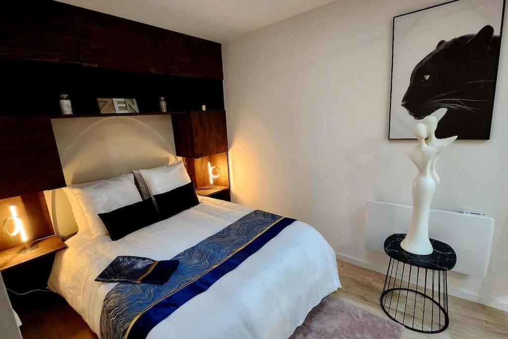 een slaapkamer met een bed en een standbeeld van een zwarte kat bij La Tanière Lens est in Sallaumines