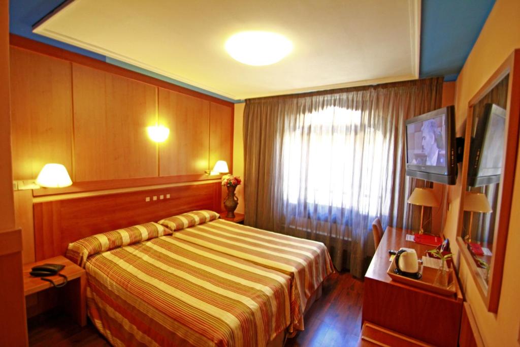 a hotel room with a bed and a window at Hotel Paris Centro in Zaragoza