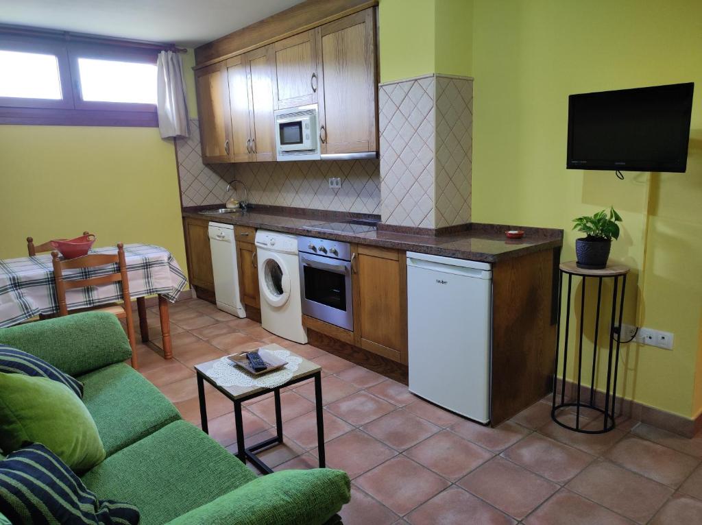 a living room with a couch and a kitchen at Apartamento Rural in Cangas de Onís