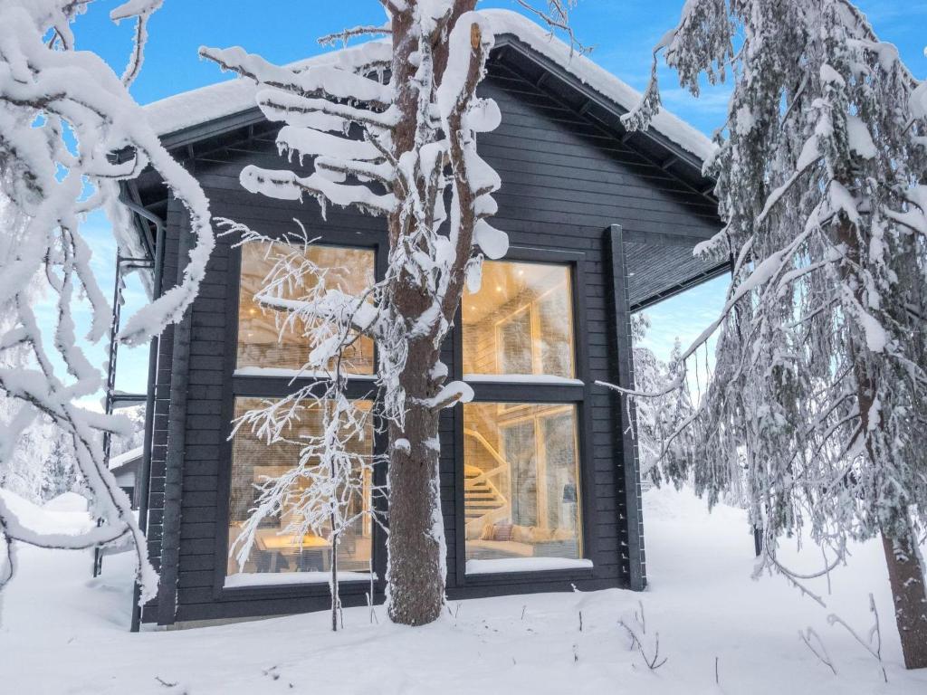a log cabin in the snow with a tree at Holiday Home Levin hiihtäjä by Interhome in Sirkka