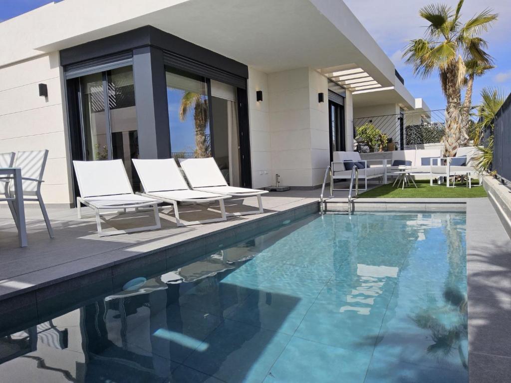 een zwembad met stoelen en een huis bij Villa Polop Hills-2 by Interhome in Polop