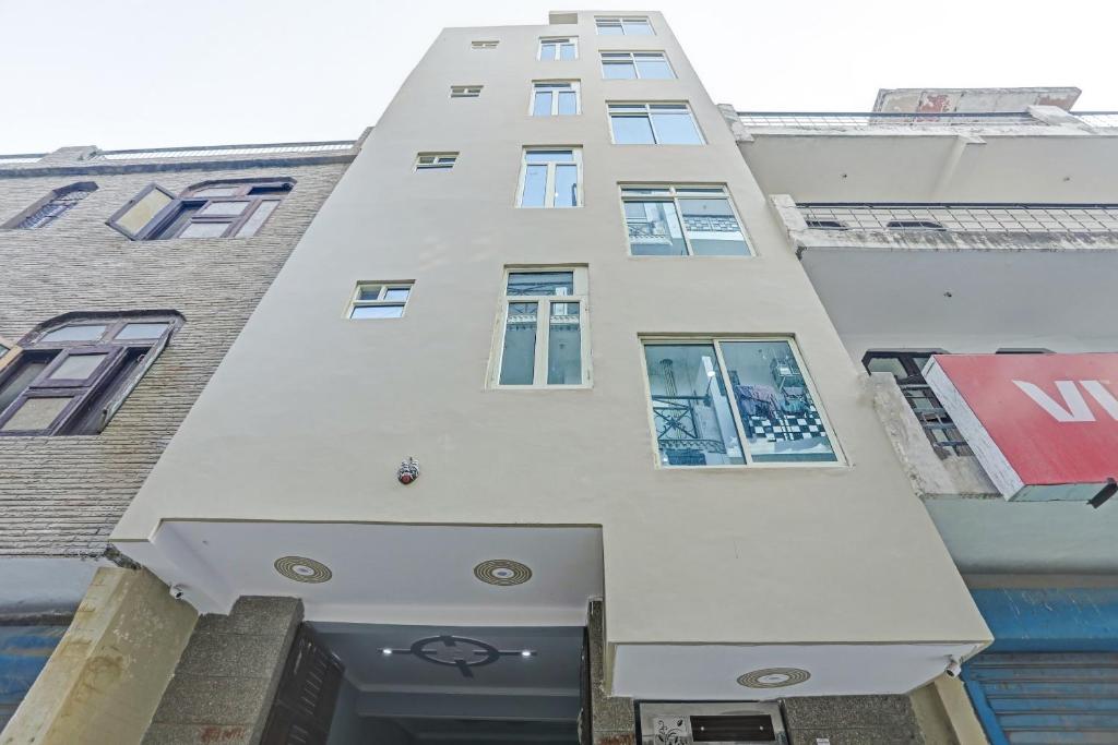 a tall white building with windows and a door at Flagship Prithvi Residency in New Delhi