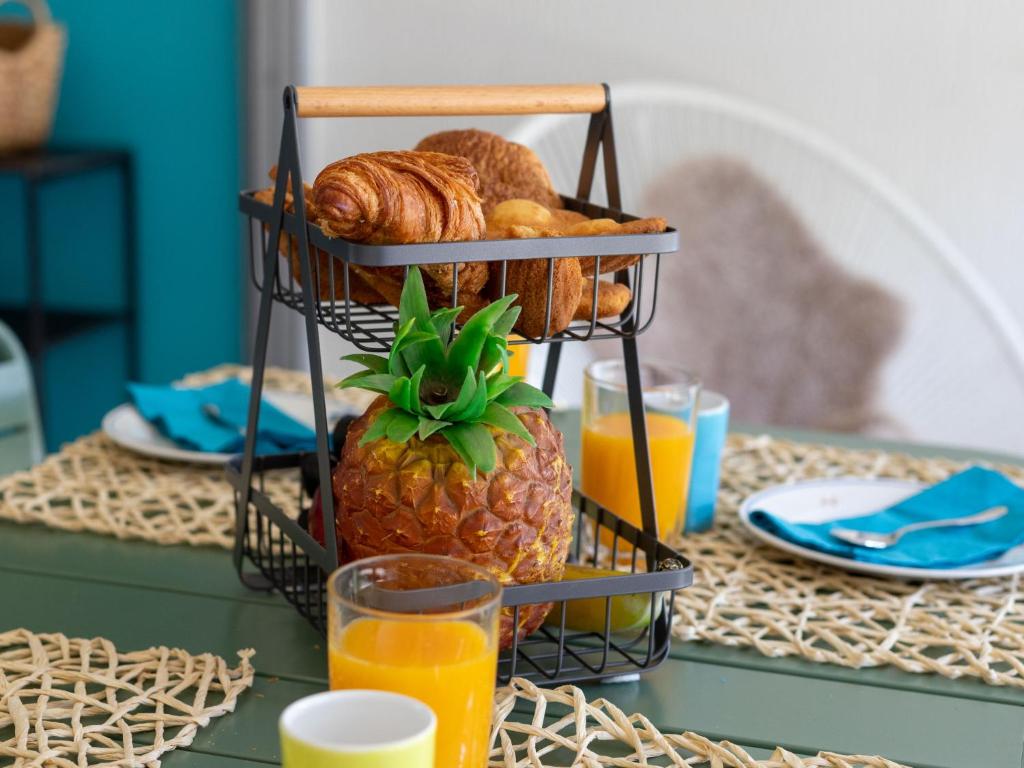 a basket of bread and a pineapple on a table at Studio East Land-3 by Interhome in La Grande Motte