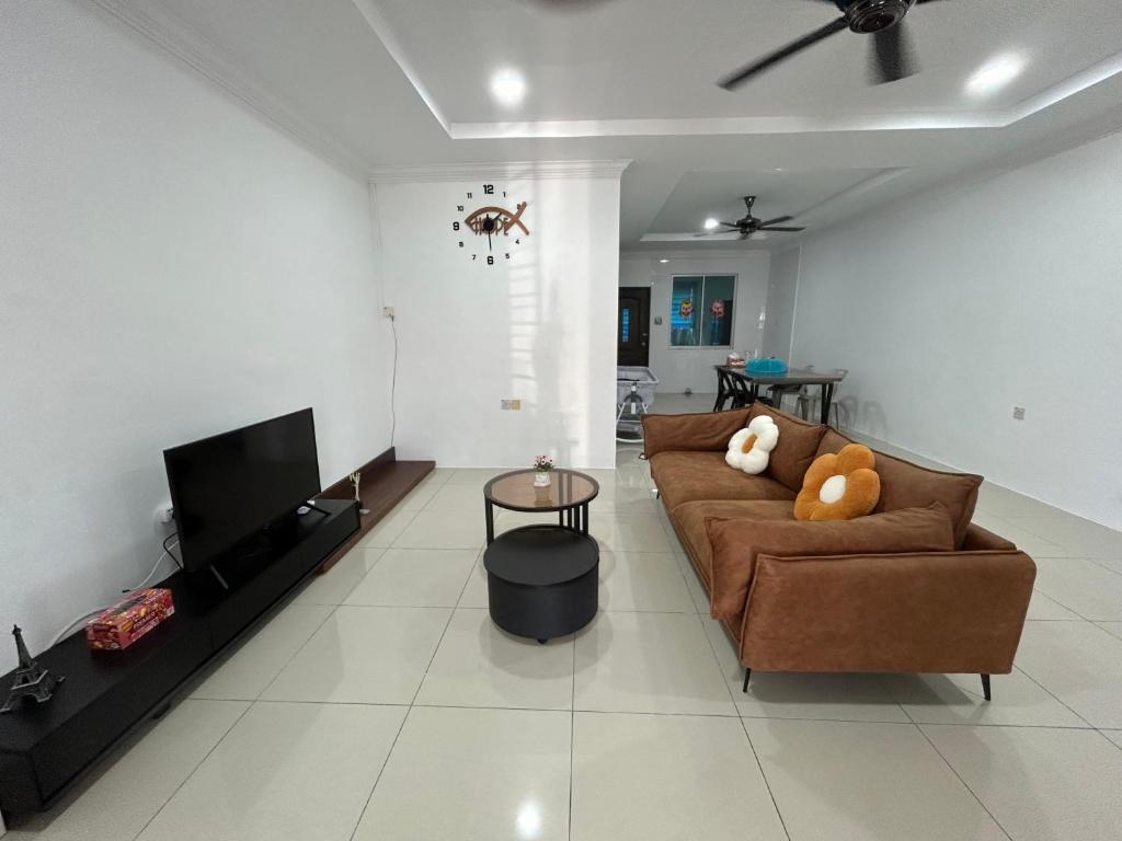 sala de estar con sofá y TV de pantalla plana en H&N Airbnb, en Miri