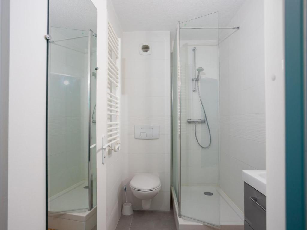 a white bathroom with a shower and a toilet at Studio East Land-3 by Interhome in La Grande Motte
