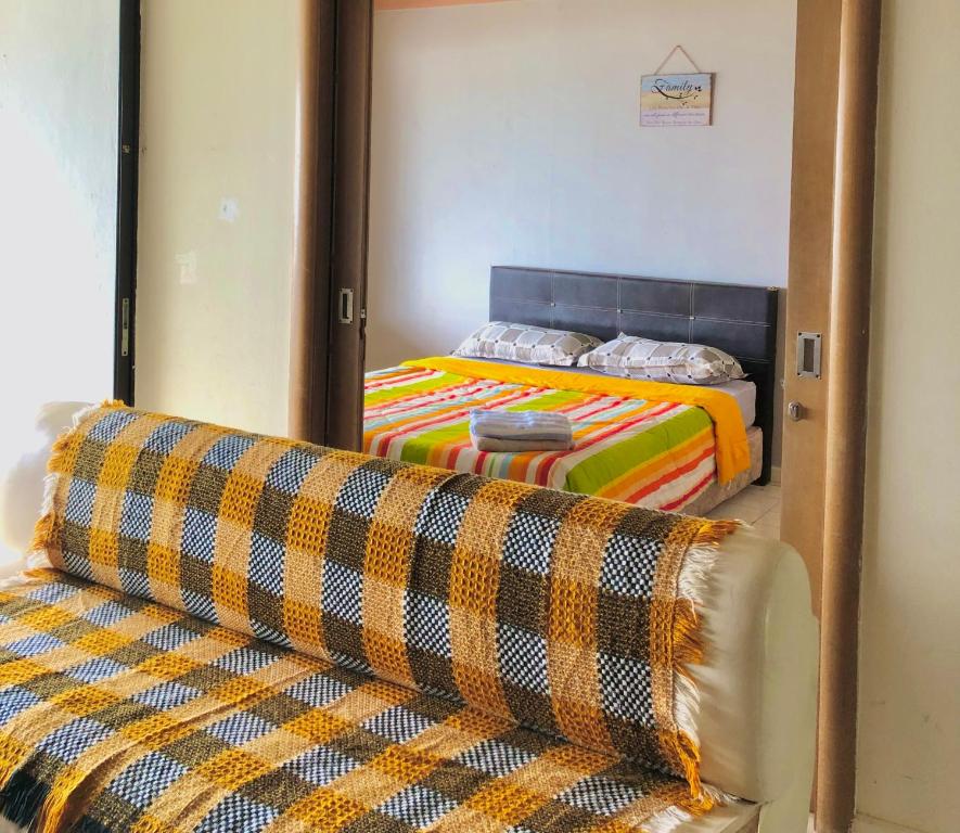 a bedroom with a bed and a couch and a mirror at PD Infront Seaview in Port Dickson