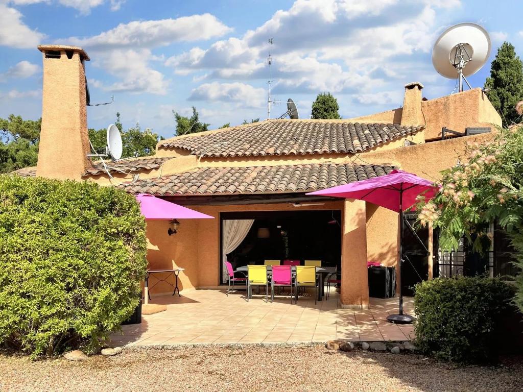 a house with a patio with pink umbrellas at Villa de 4 chambres a Porto Vecchio a 160 m de la plage avec jardin clos et wifi in Porto-Vecchio